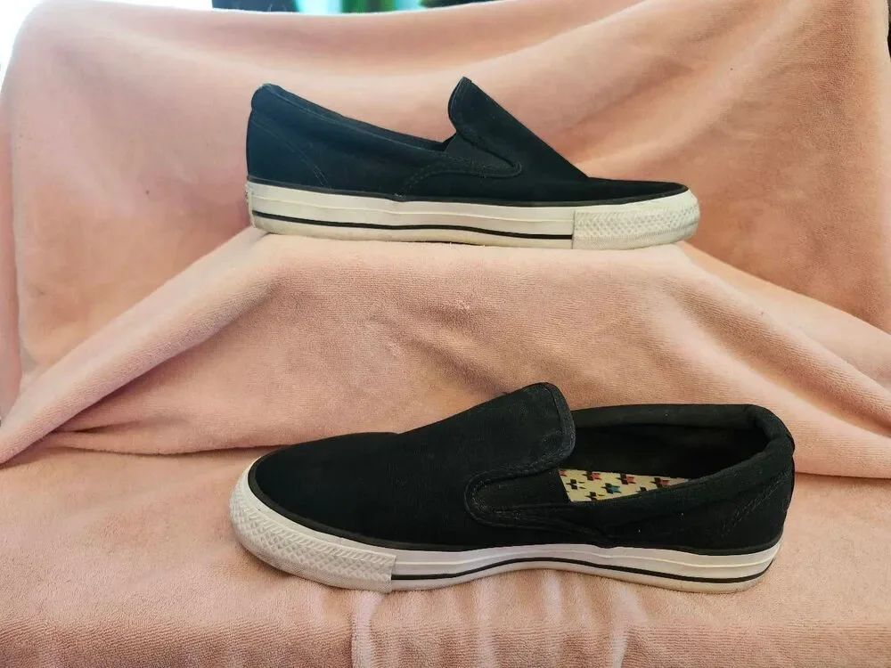 Converse All Star slip-ons feature a classic black canvas upper and a white rubb